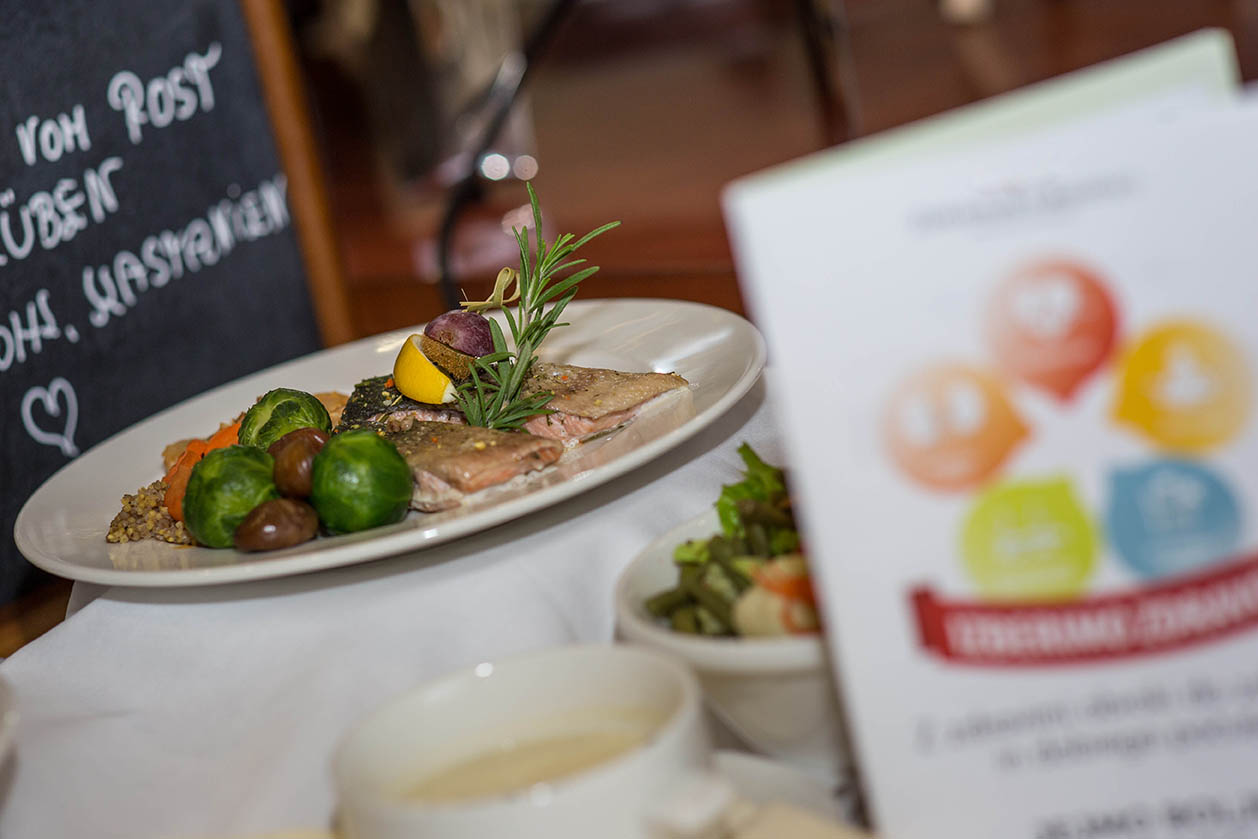 Krožnik na beli mizi z zelenjavo in zrezkom