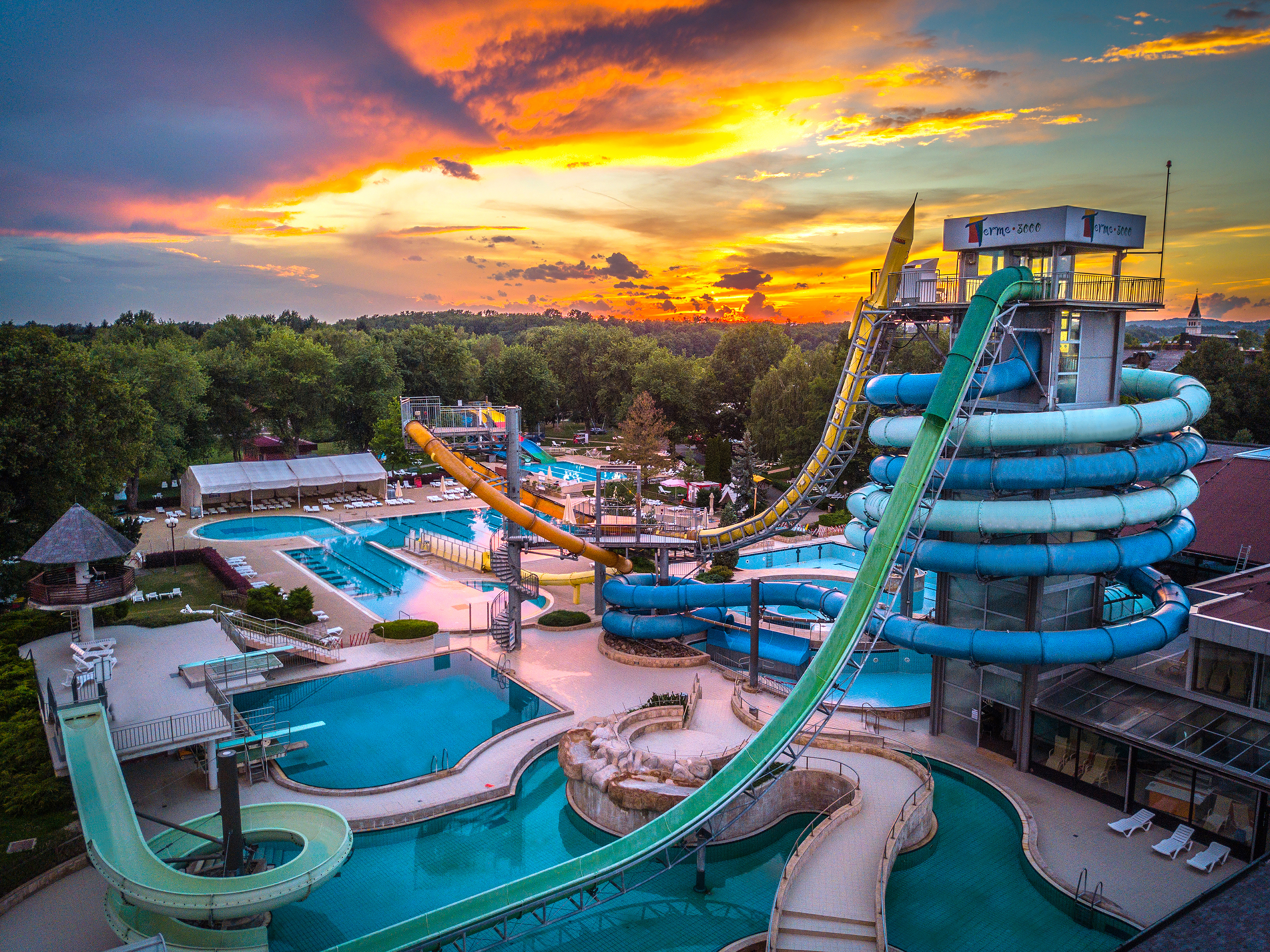 Panorama zunanjega kompleksa bazenov in vodnega parka ob sončnem zahodu
