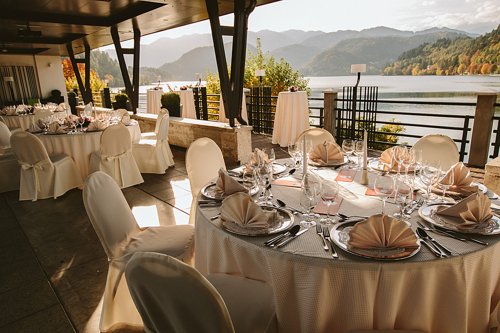 Lepo urejena terasa hotelske restavracije ob Blejskem jezeru s pripravljenimi mizami in stoli